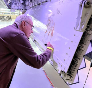 Robert Moore signs the nose art he painted on Evergreen's F-117 Lone Wolf 18 years after he originally created it. 